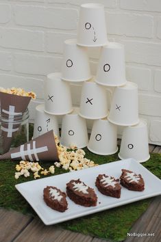 a table topped with white cups filled with chocolate covered cookies