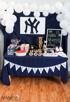 a new york yankees party table with balloons and food on it, including candy bar