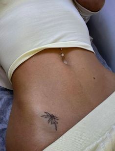 a woman's stomach with a small tattoo on her belly and the bottom part of her abdomen