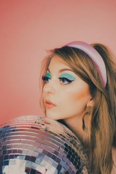 a woman with blue eyes holding a disco ball