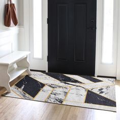 a black and white door with a bench in front of it on a wooden floor