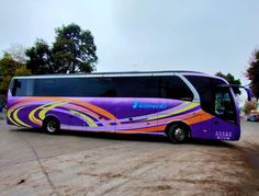 a purple and orange bus parked in a parking lot