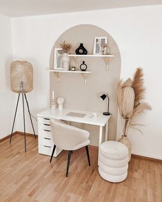 a white desk and chair in a room with wood flooring, shelves on the wall