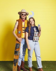 two people dressed up as woody and the person from toy storyland posing in front of a yellow wall