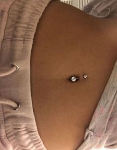 a woman's stomach with two piercings attached to the side and an earring on it