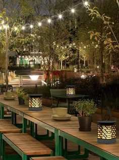 an outdoor dining area with benches and lights