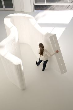 a woman is standing in the middle of a room with white walls and flooring