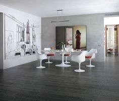 a dining room with white chairs and an art work on the wall