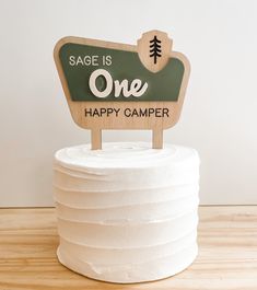 a wooden sign that says sage is one happy camper on top of a cake