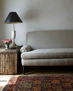 a white couch sitting next to a lamp on top of a table