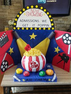 a chair with popcorn on it and a sign that says now showing, graduations we get it poppin