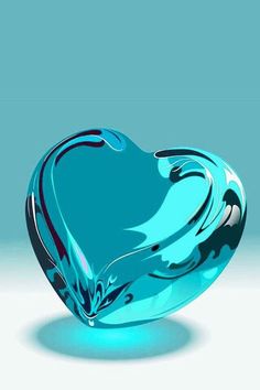 a blue glass heart shaped object sitting on top of a white table next to a cell phone