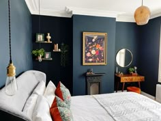 a bedroom with blue walls and white bedding