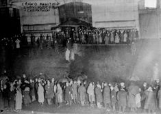 an old black and white photo of people standing in front of a train