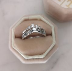 two wedding rings sitting in a velvet ring box