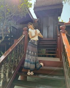 a woman standing at the top of some stairs