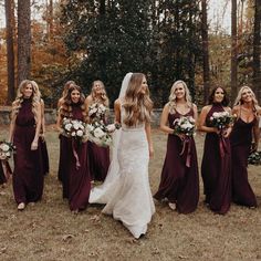 a bride and her bridesmaids walking through the woods with their bouquets in hand