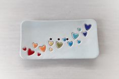 a white plate topped with lots of different colored hearts