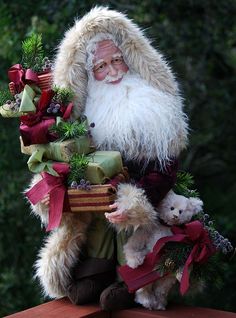 a statue of santa claus holding two small dogs and presents on top of a table