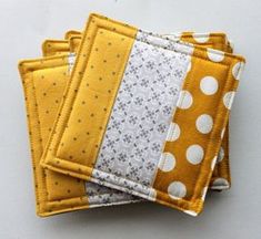 four yellow and white coasters are stacked on top of each other with polka dots