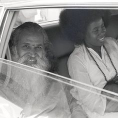 an old black and white photo of two people in the back seat of a car