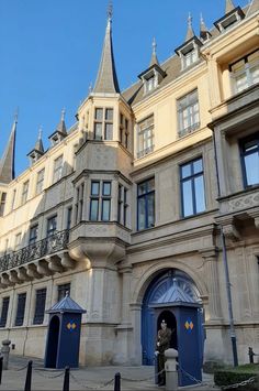 an old building with blue doors and towers on the top of it's roof