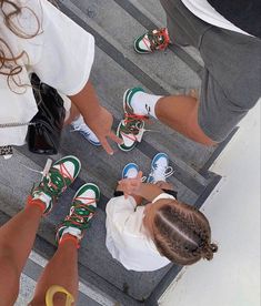 three people standing in the middle of a crosswalk with their feet up and one person pointing at them