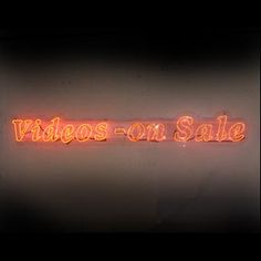 a neon sign that reads videos on sale