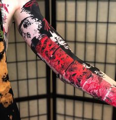 the arm is covered with red and black ink as it stands in front of a wall