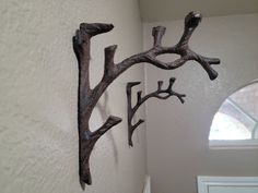 two metal branches are hanging on the wall