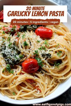 a white bowl filled with pasta topped with tomatoes and parmesan