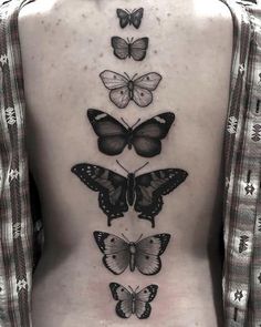 a woman's back with four butterflies on her side and the bottom part of her body