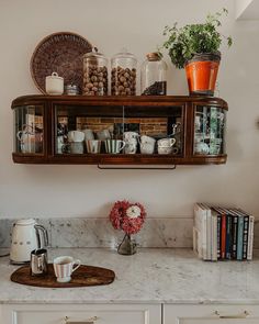 a kitchen counter with coffee cups and books on it