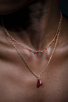 Anet's Collection seed of life single pomegranate seed Necklace in Gold paired with red dotted necklace. In Armenian mythology the pomegranate symbolizes fertility and abundance. The fruit is the Armenian symbol of life and tradition tells us that each mature pomegranate has 365 seeds, one for each day of the year. Length: 16" & 18" Pom seeds: Formica 2mm 14 K gold plated double necklace, can be used separately or together Brass casting Pomegranate Seed Necklace, Red Amulet Necklace For Meditation, Red Amulet Necklace With Polished Beads, Red Amulet Pendant Necklace, Red Teardrop Jewelry With Tiny Beads, Red Coral Pendant Necklace As Gift, Red Coral Pendant Necklace For Gift, Red Beaded Amulet Style Jewelry, Spiritual Red Beaded Pendant Necklace