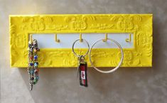 there is a yellow frame with two key chains hanging on it