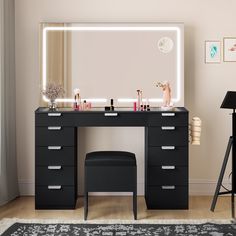 a black vanity with lighted mirror and stool