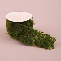 a roll of moss sitting on top of a pink tablecloth next to a white plate