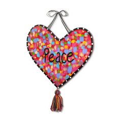 a heart shaped decoration with the word peace hanging from it's side and a tassel