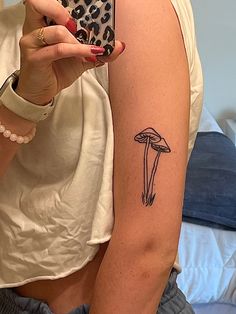 long, thin mushroom tattoo on upper arm