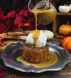 a dessert is being drizzled with caramel sauce on a glass plate