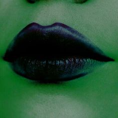 a woman's lips with green and black lipstick on them, as if she was in the movie maleficent