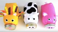 three stuffed animals are lined up in the shape of cans with faces painted on them