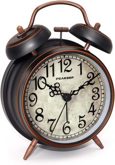 an old - fashioned alarm clock is shown with the hands pointing to twelve o'clock