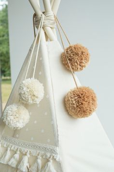 three pom - poms hanging from the top of a teepeel tent