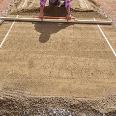 a man kneeling down on top of a dirt field