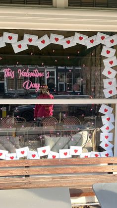 a valentine's day window display with paper hearts