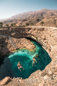 two people are swimming in the clear blue water