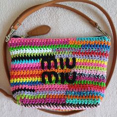 a multicolored crocheted purse with the word no uu on it