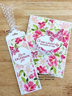 two tags with flowers and butterflies on them, one has a tag that says celebrate