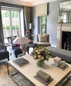 a living room filled with furniture and a fire place in front of a mirror wall